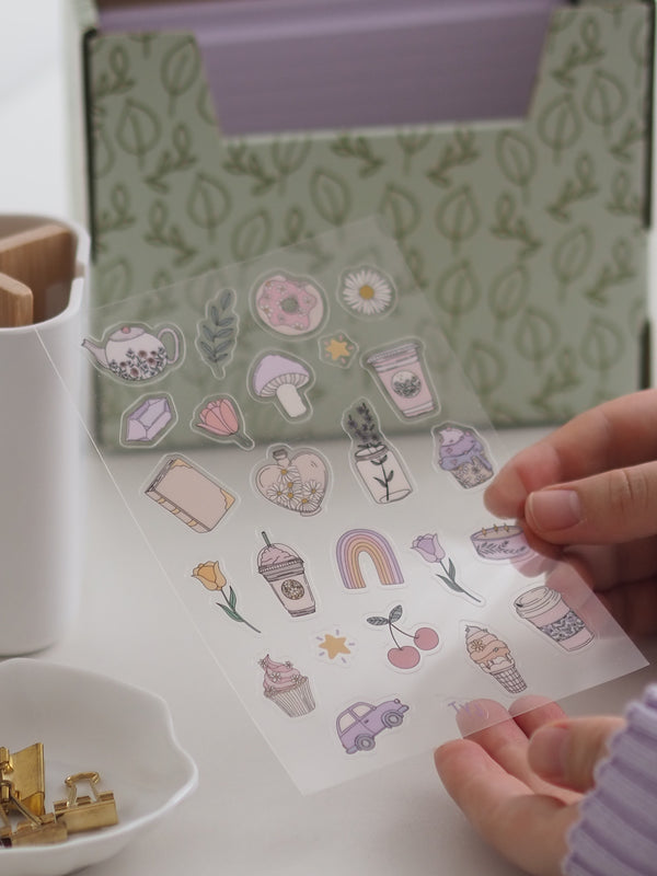 Sticker-Sheet lovendel mit lila Stickern in der Hand