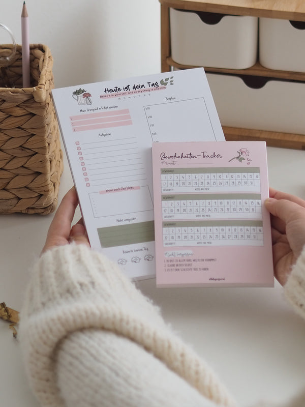 Tagesplaner und Gewohnheiten-Tracker im Set in der Hand
