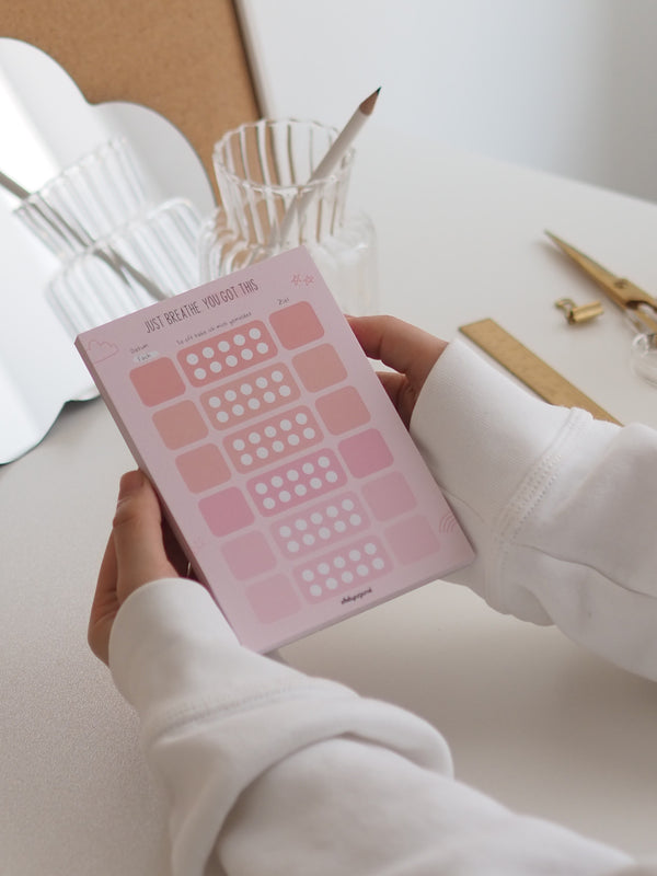 Meldeliste A6 in Rosa mit Feldern zum Abhaken in der Hand