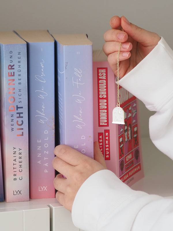 Lesezeichen magic mit Anhänger am Bücherregal