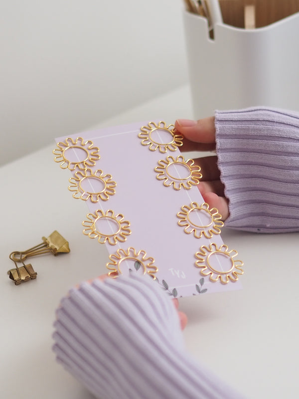 Büroklammer-Set daisy mit goldenen Blumen-Büroklammern auf lila Karte