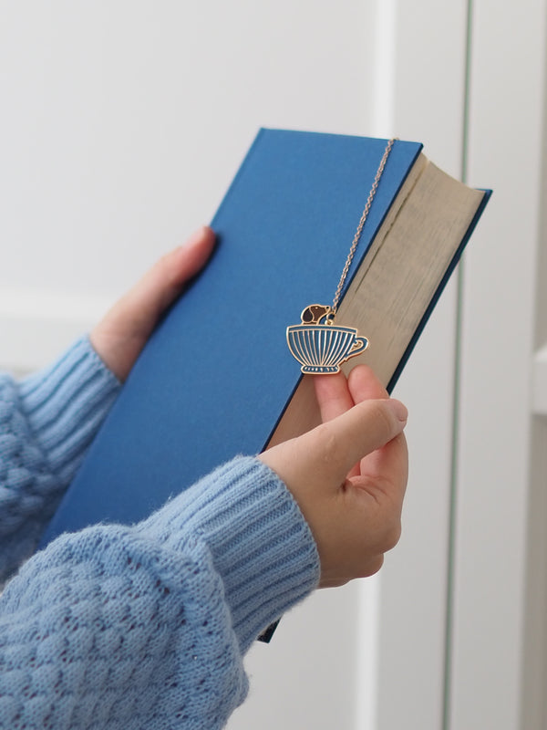 Lesezeichen Dackel mit Tassen-Anhänger im blauen Buch